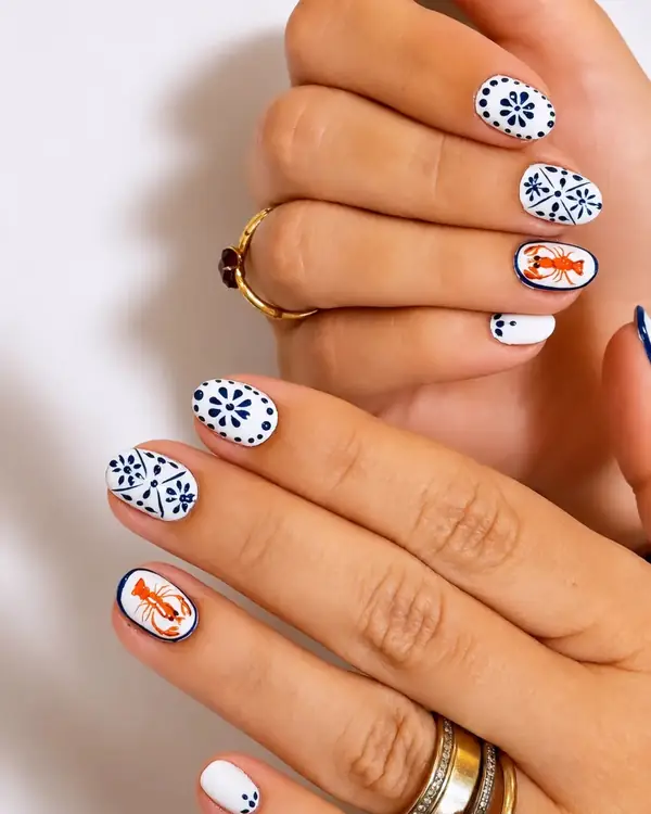 Uñas blancas con diseño de azulejo en azul y naranja, trabajo de Glowy