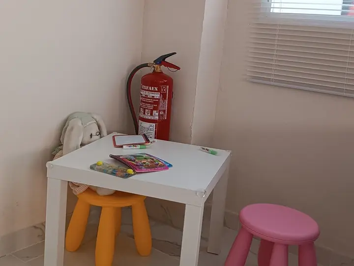 Rincón infantil con mesa y taburetes de colores