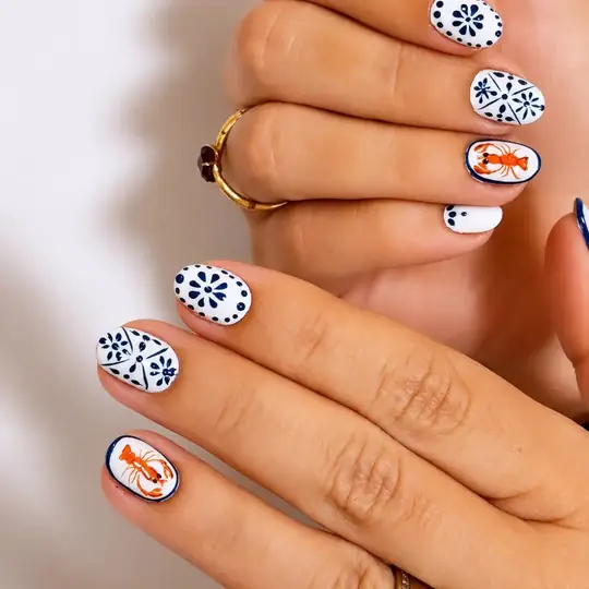Uñas blancas con diseño de azulejo azul y naranja