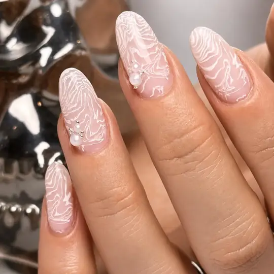Uñas almendradas nude con relieve blanco tipo encaje